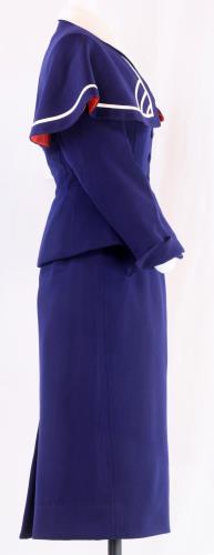 Side view of a navy wool skirt and jacket over a sheer, synthetic button-down blouse from the 1940s