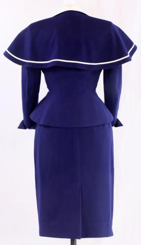 Back view of a navy wool skirt and jacket over a sheer, synthetic button-down blouse from the 1940s