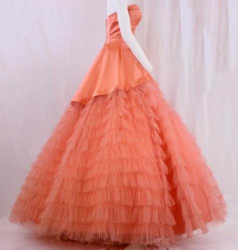 Side view of a salmon colored strapless satin gown from the 1950s