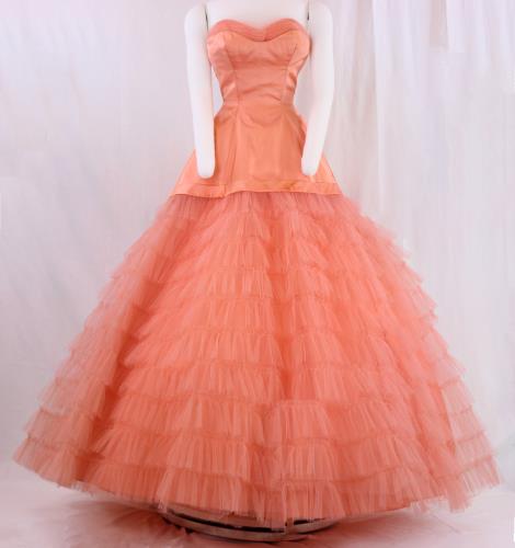 Front view of a salmon colored strapless satin gown from the 1950s