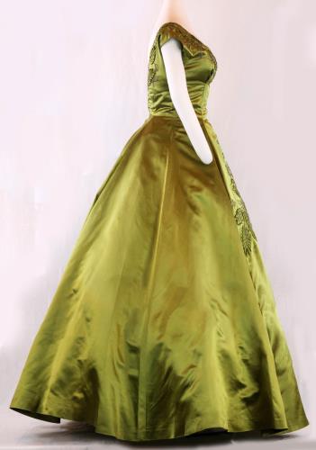 Side view (lighter) of a olive green, floor length, acetate satin evening gown from the 1950s