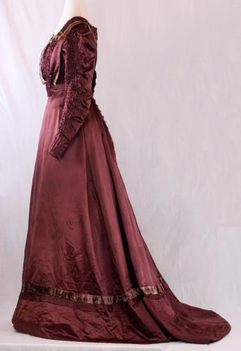 Side view of a long maroon satin empire gown from the 1910s