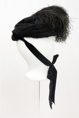 Right side view of a black feather hat from the 1890s