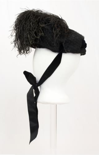Left side view of a black feather hat from the 1890s