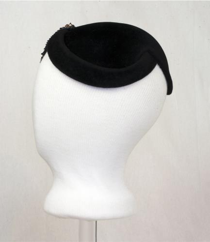 Left side view of a black velvet hat with pink sequens, circa 1950.
