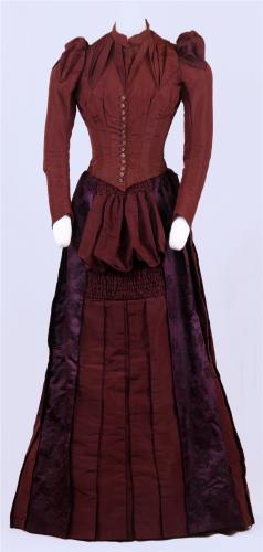 Front view of a hannifin burgandy dress, circa 1880.