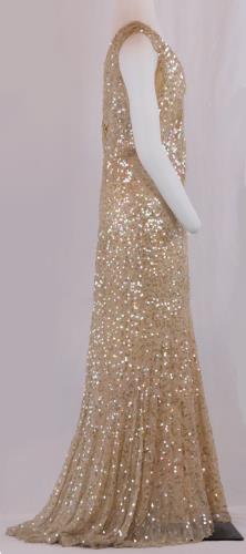 Side view of a floor length, sleeveless, sequined peach silk chiffon, circa 1930.