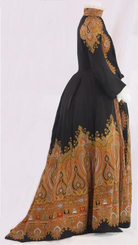Side view of a black and paisley dress from the 1890s
