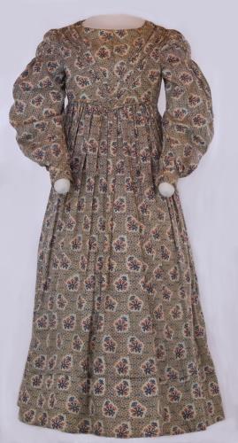 Front view of a long sleeved flower print pioneer ladies dress from the 1830s