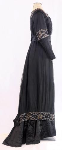 Side view of a two piece black silk gown from the 1910s